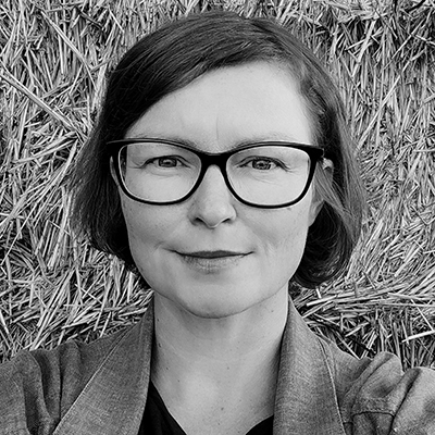 Schwarz-Weißporträt von Tina Wünschmann (Kopf), leicht lächelnd, Frau mit Brille © Tina Wünschmann